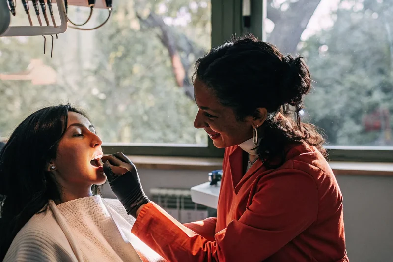 Dentist performing a gum examination on a patient in a modern dental office