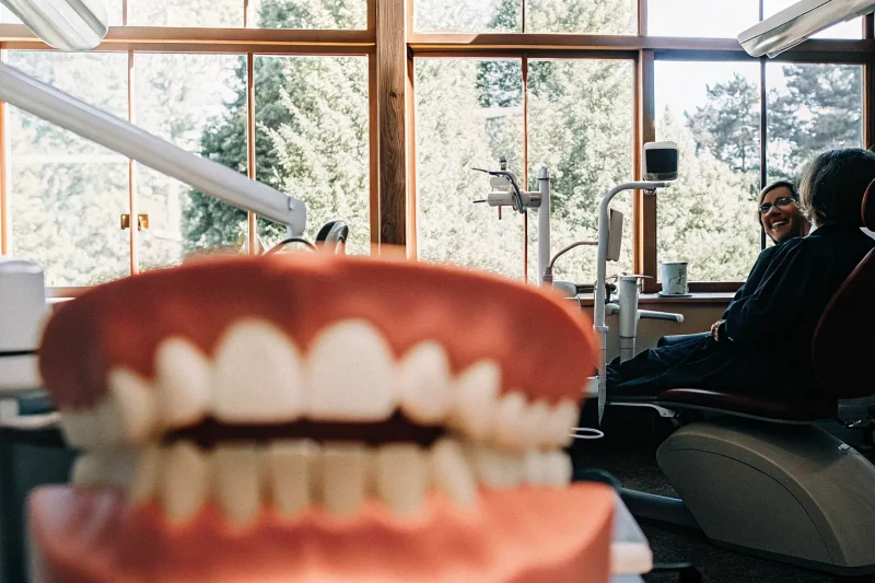 Dr. Anand Shah consulting with a patient about implant-supported denture options in a modern dental office