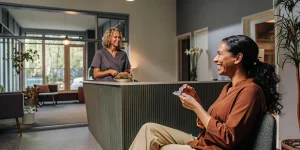 Dental patient holding clear invisible aligners in a bright modern dental office